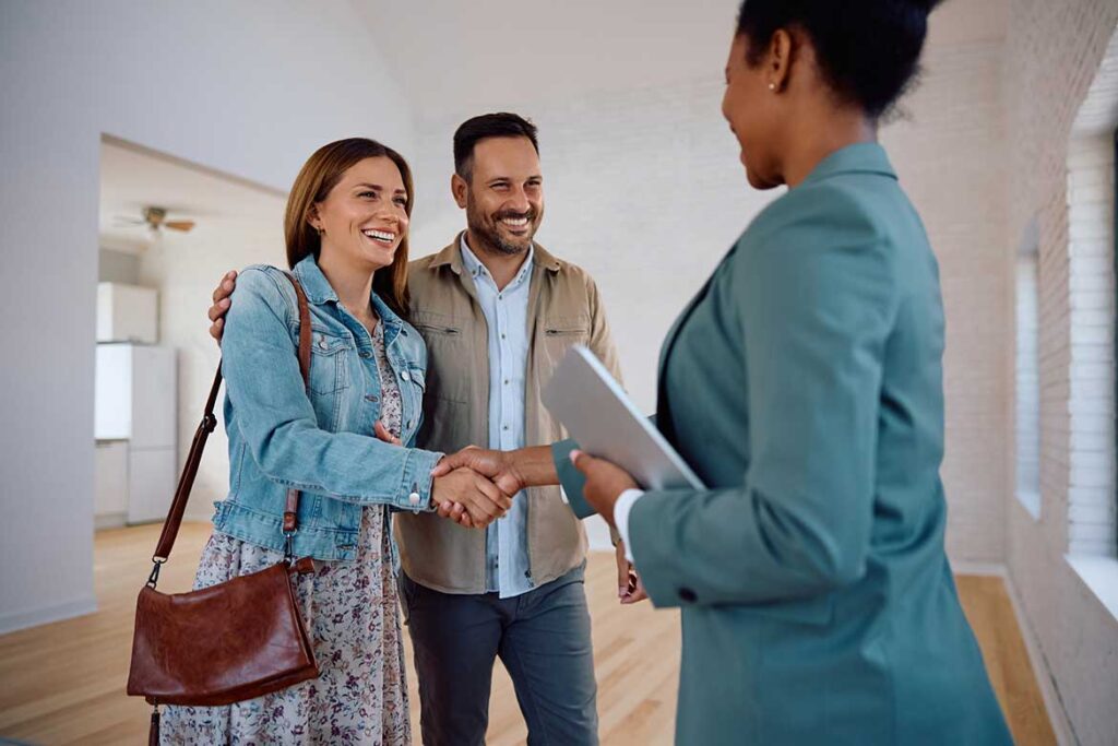 Boutique Property Management Services in Columbus, Ohio with Maximizing Outcomes, woman shaking hands as a couple inspects a potential place to live